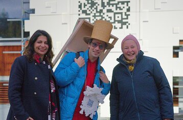 Three people in front of the installation