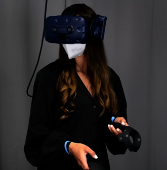 Eine Frau mit VR-Brille und Controllern in der Hand